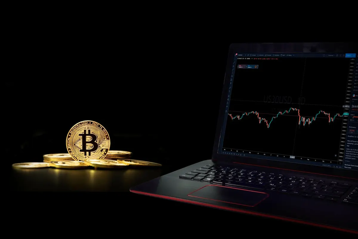 a person holding a coin in front of a computer